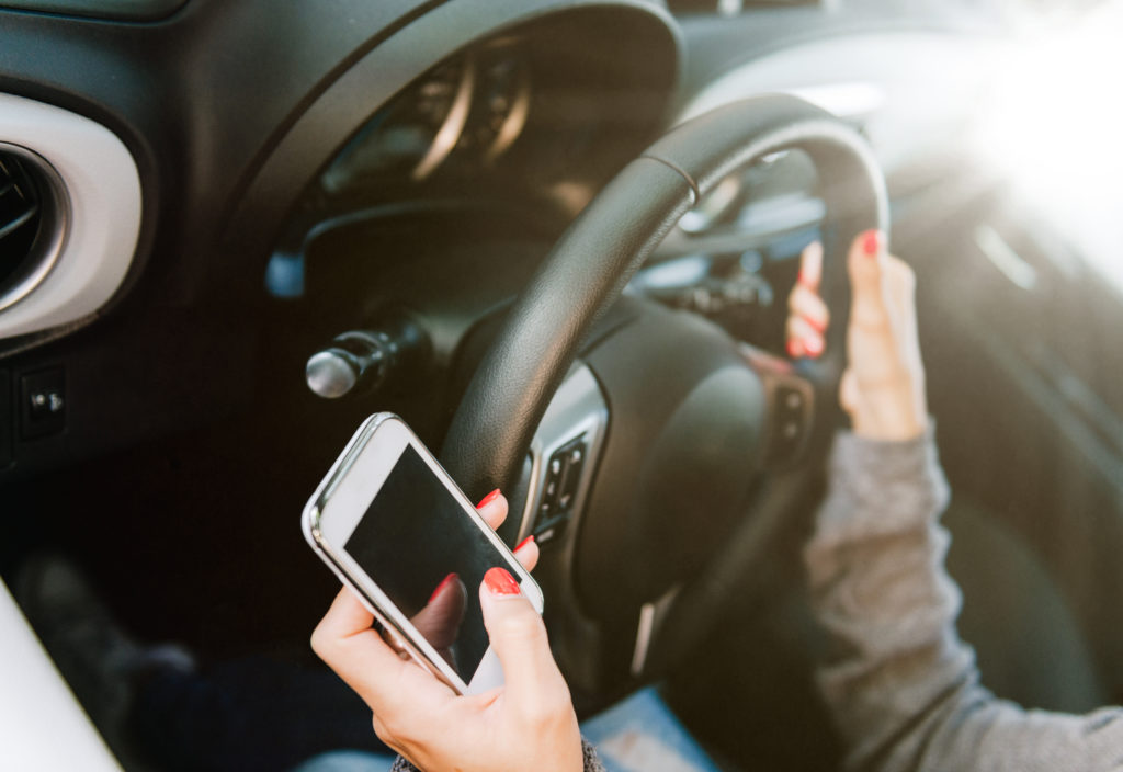 Woman Calling For Assistance On Smart Phone While Driving Vehicle